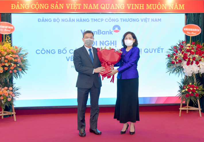 Đồng chí Nguyễn Thị Hồng - Ủy viên Ban Chấp hành Trung ương Đảng, Bí thư Ban cán sự Đảng, Thống đốc Ngân hàng Nhà nước Việt Nam tặng hoa chúc mừng đồng chí Trần Minh Bình - tân Bí thư Đảng ủy, Chủ tịch HĐQT VietinBank