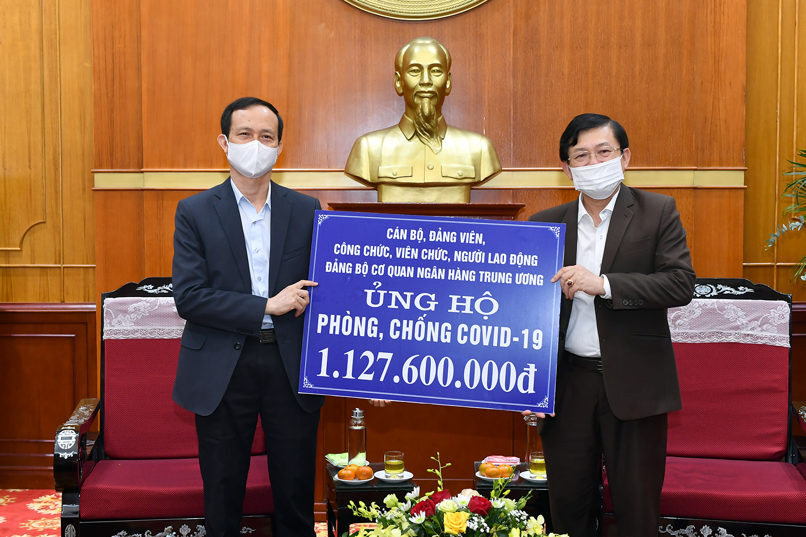 Đ/c Trần Việt Bắc, Phó Bí thư thường trực Đảng ủy cơ quan NHTW và đ/c Nguyễn Hữu Dũng, Phó Chủ tịch Ủy ban Trung ương MTTQ Việt Nam trao và tiếp nhận ủng hộ