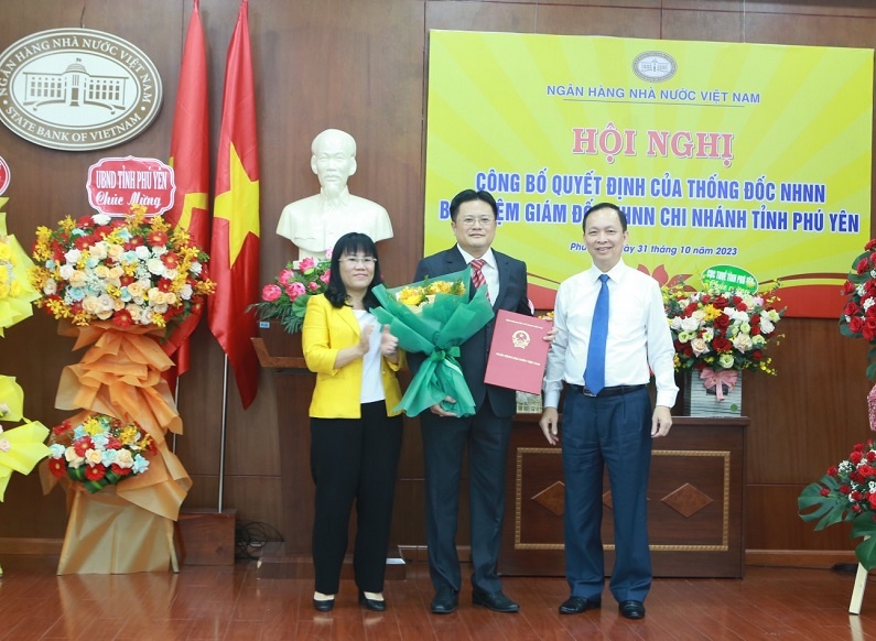 Phó Thống đốc Thường trực NHNN Đào Minh Tú và Phó Chủ tịch UBND tỉnh Hồ Thị Nguyên Thảo trao quyết định, tặng hoa chúc mừng đồng chí Hoàng Linh, tân Giám đốc NHNN chi nhánh tỉnh Phú Yên