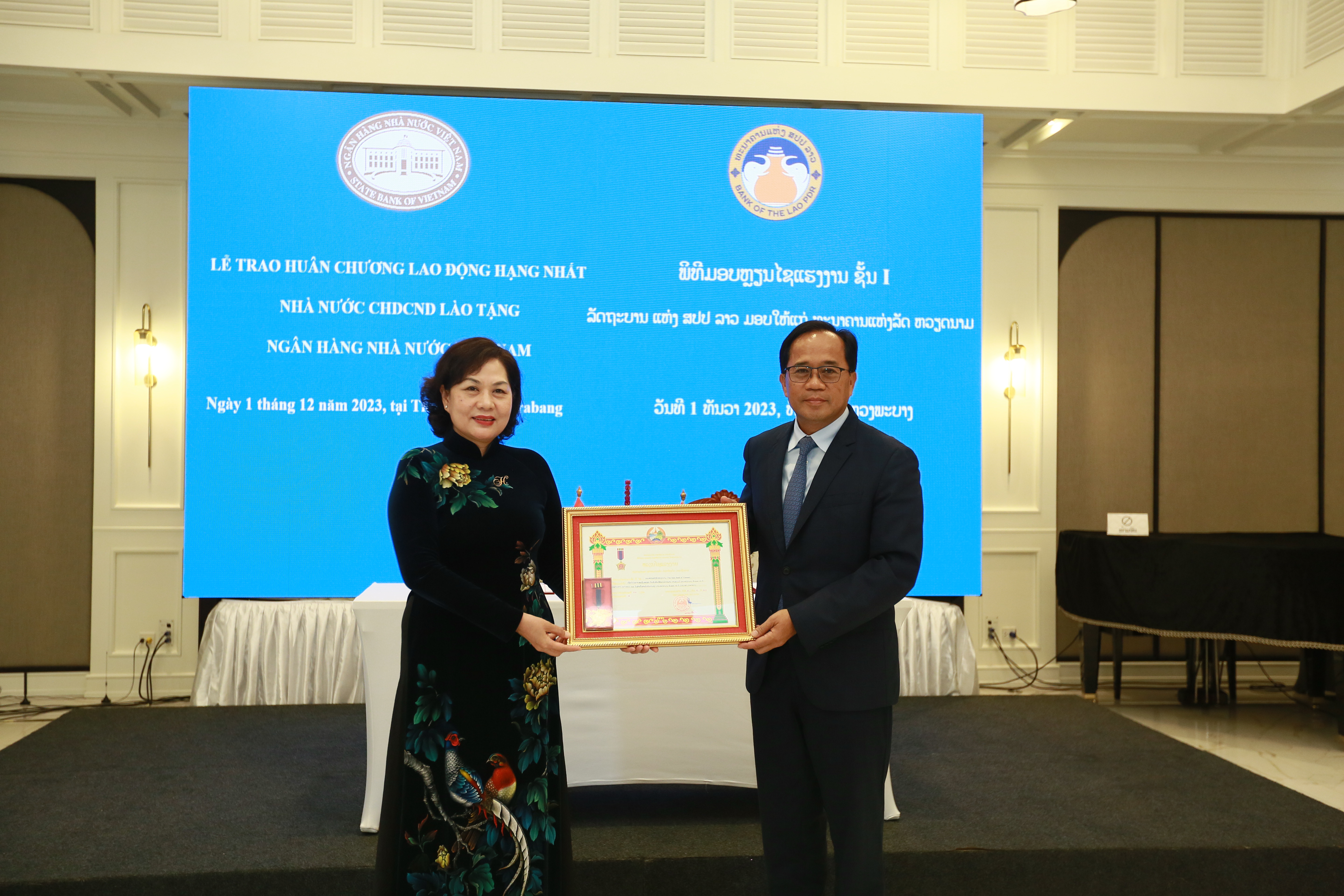 Thay mặt Nhà nước CHDCND Lào, Thống đốc Bounleua Sinxayvoravong đã trao tặng Huân chương Lao động hạng nhất của Nhà nước Cộng hòa Dân chủ Nhân dân Lào cho NHNN, Thống đốc Nguyễn Thị Hồng đã thay mặt NHNN vinh dự đón nhận