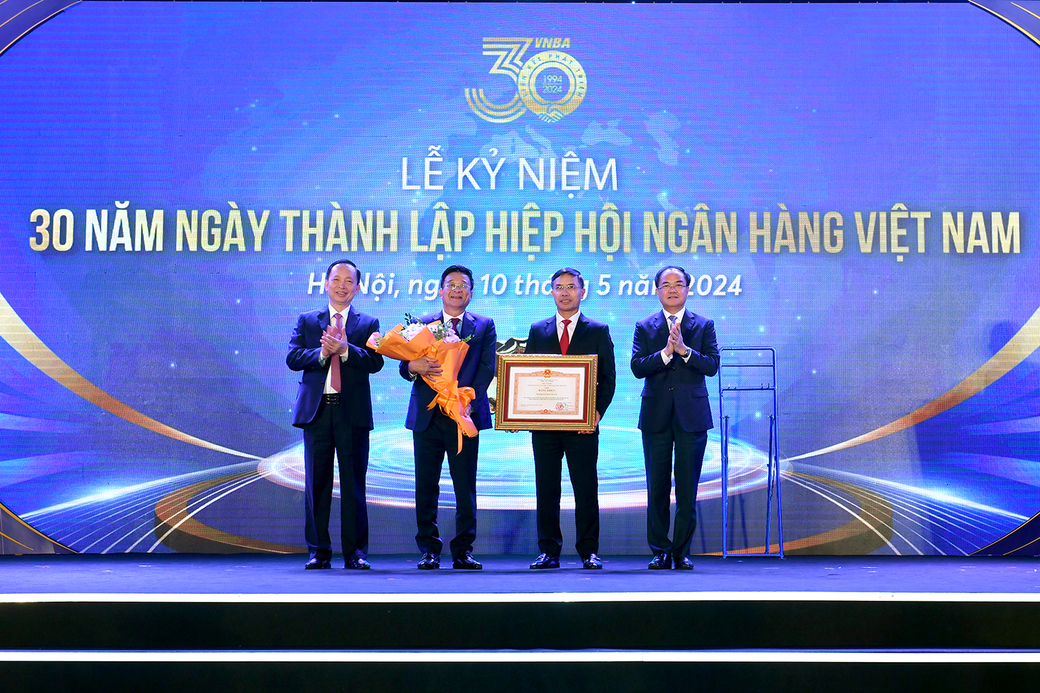 Phó Thống đốc thường trực Đào Minh Tú và Thứ trưởng Bộ Nội vụ Vũ Chiến Thắng trao Bằng khen của Thủ tướng Chính phủ cho HHNH tại Lễ Kỷ niệm