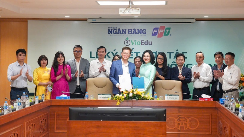 Đại diện Thời báo Ngân hàng và đại diện Tập đoàn FPT trao biên bản hợp tác